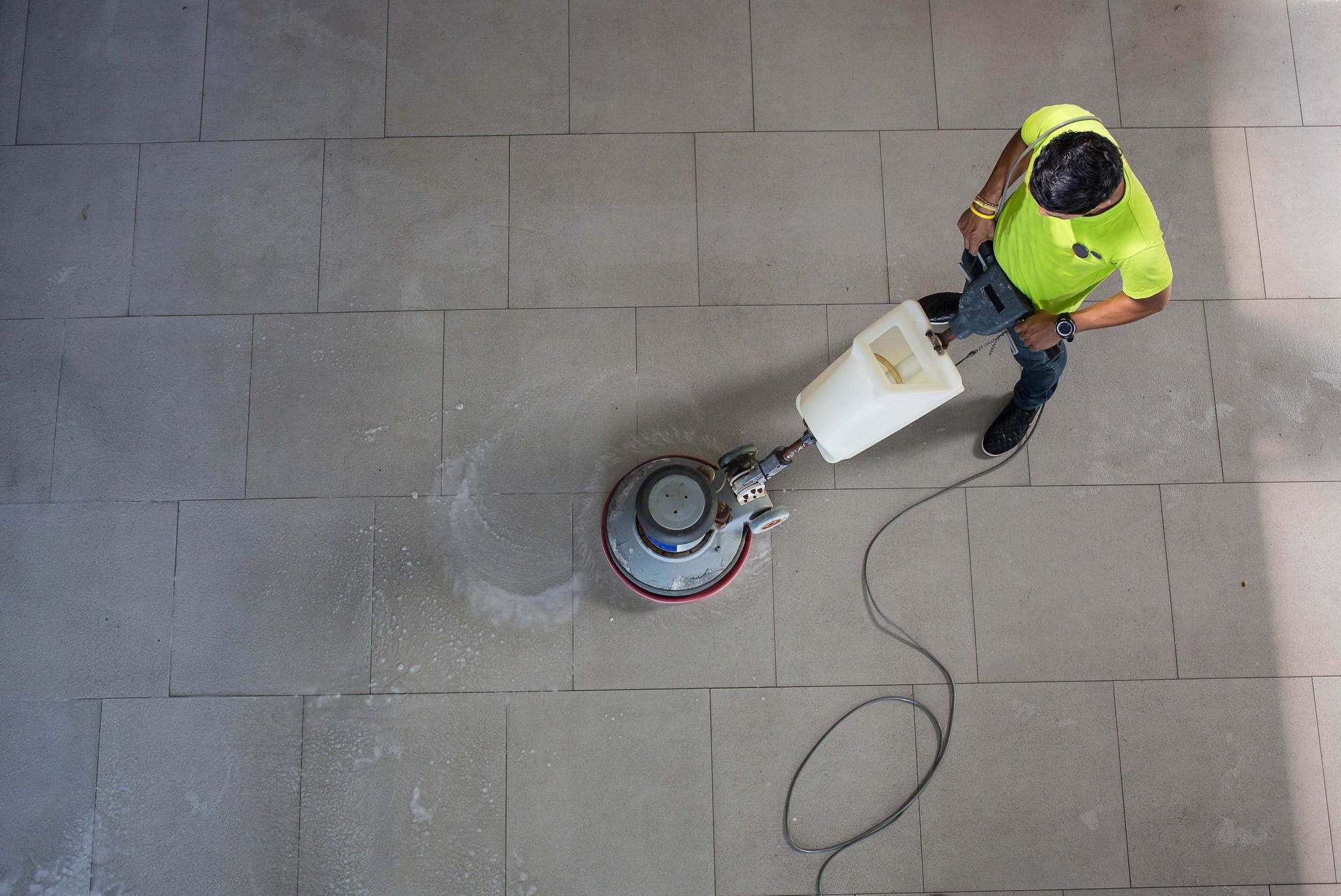 person using floor polisher to clean floor